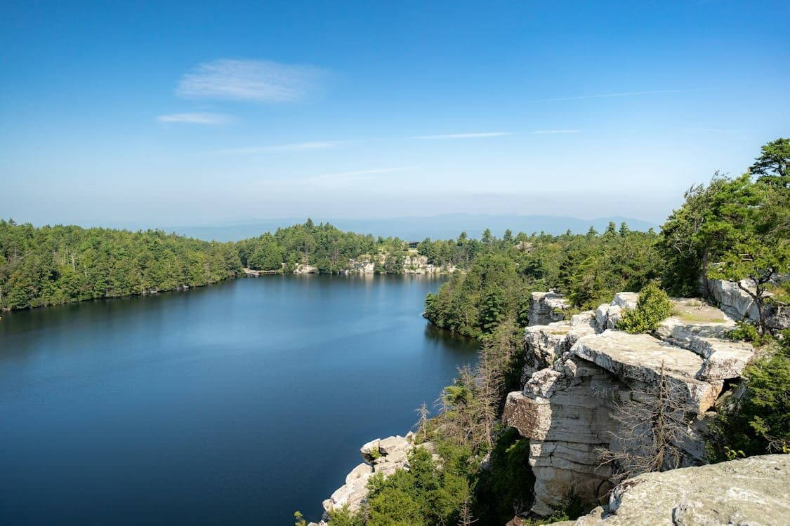 Clear blue lake ringed by forest and white rock cliffs